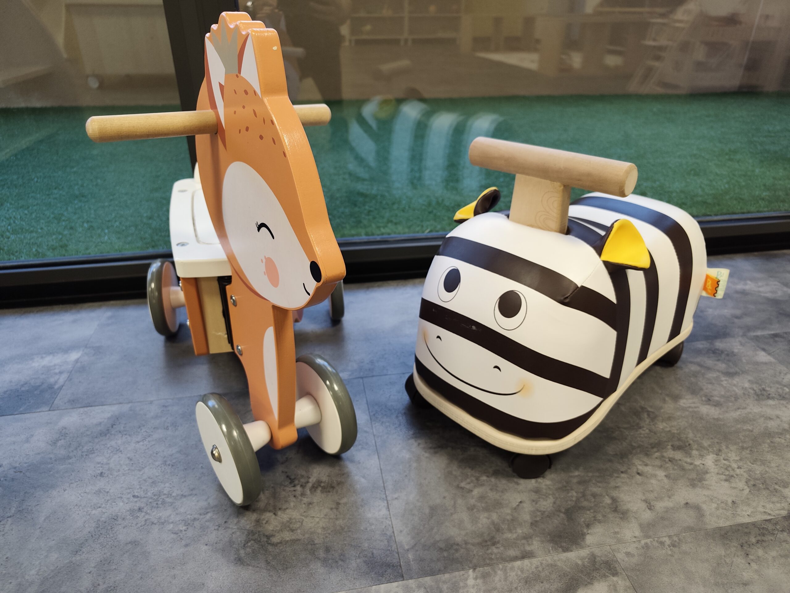 Jeux porteurs et véhicules pour jeunes enfants dans l’espace intérieur de la micro-crèche