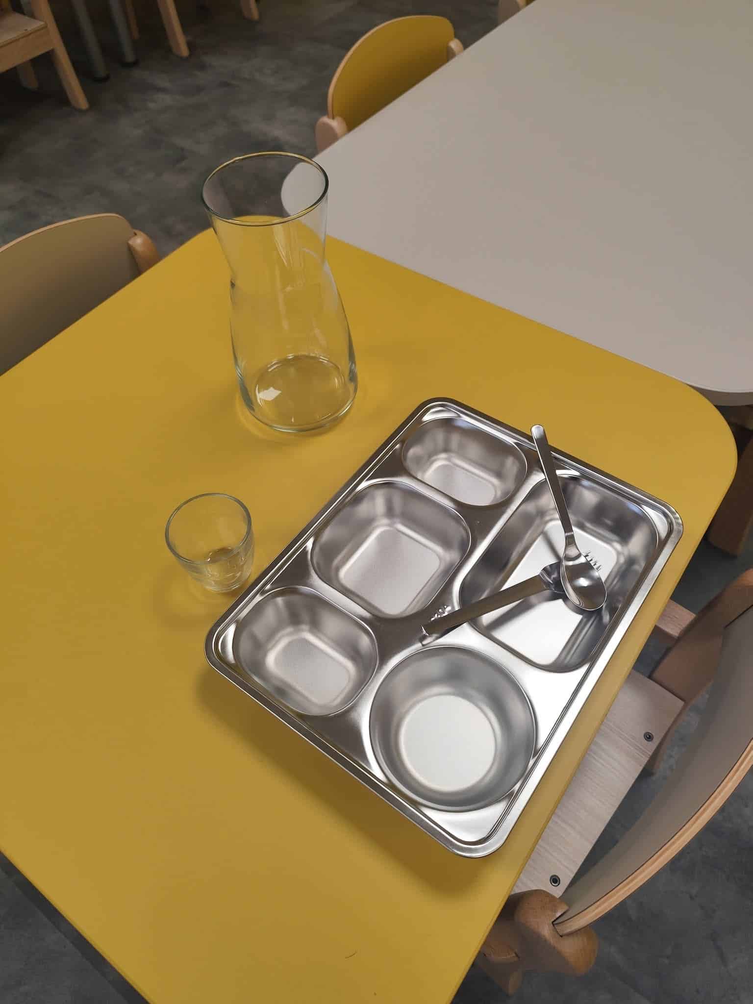 Espace repas avec vaisselle adaptée aux jeunes enfants à la micro-crèche