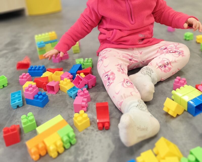 Enfant jouant avec des cubes colorés dans un espace petite enfance